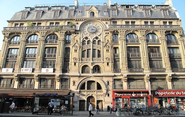 A historic building with ornate architectural details, including a large clock, arched windows, and balconies.