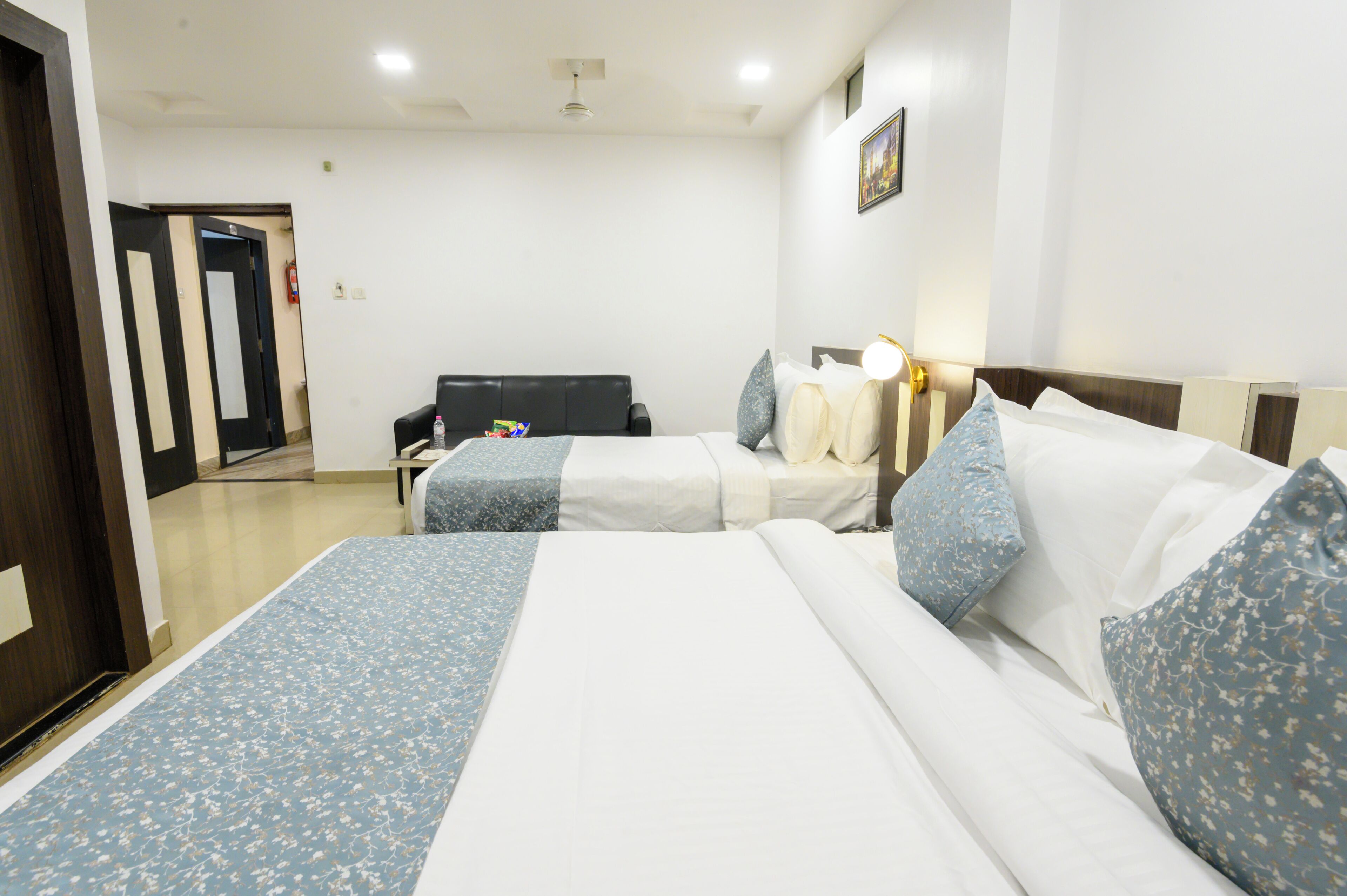 A hotel room with two beds, a desk, and a chair.