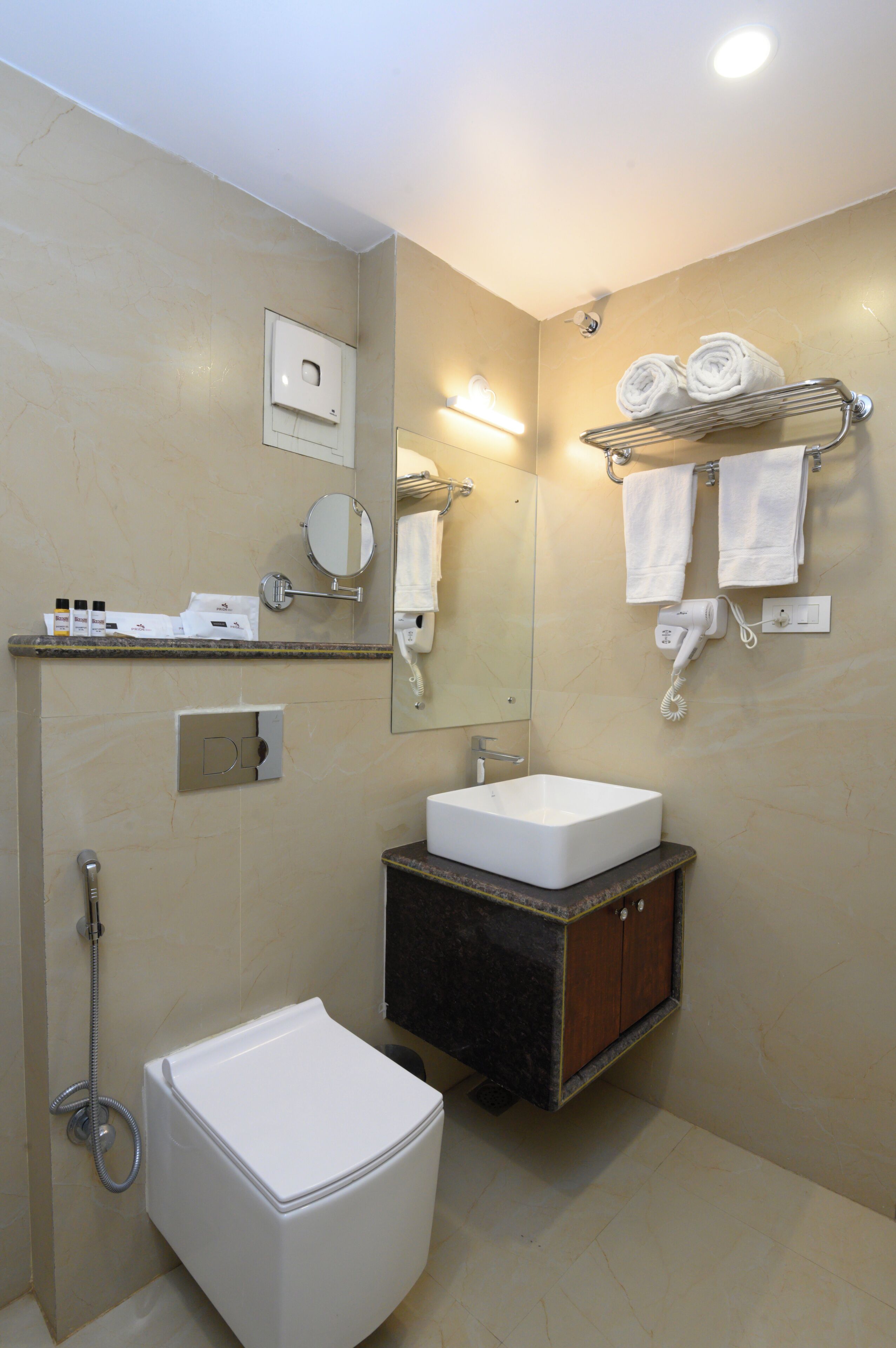 A bathroom with a white toilet, a sink, a mirror, and a towel rack.