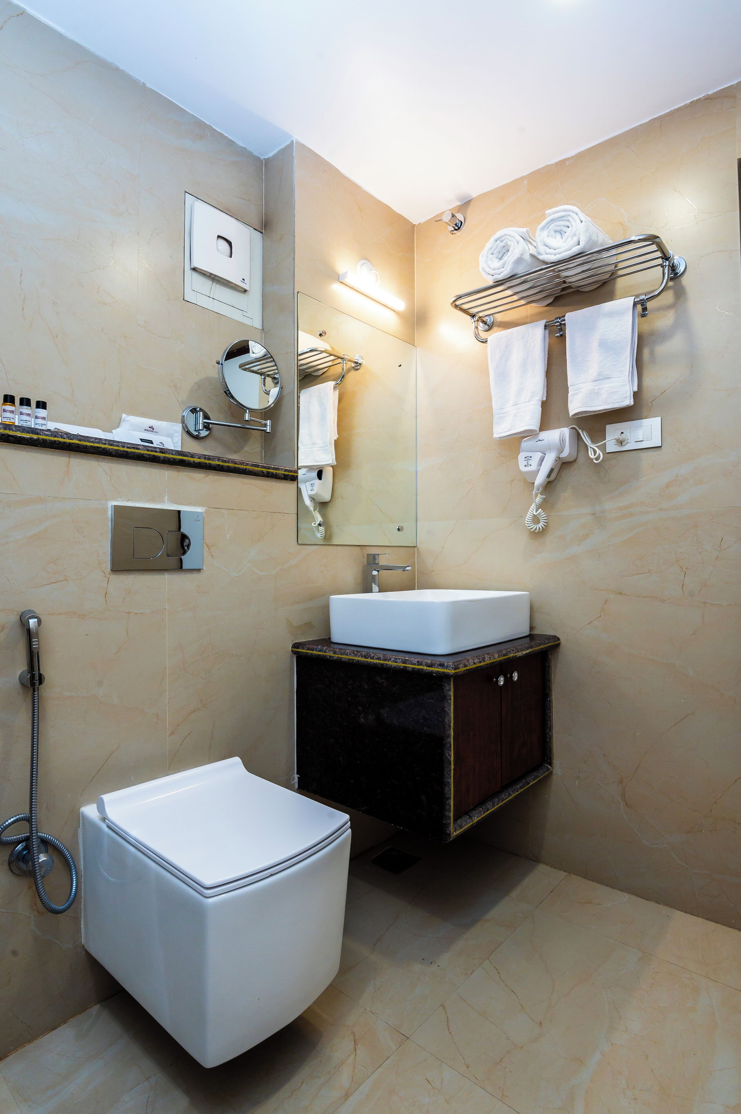 Een moderne badkamer met toilet, wastafel en handdoekhouder.