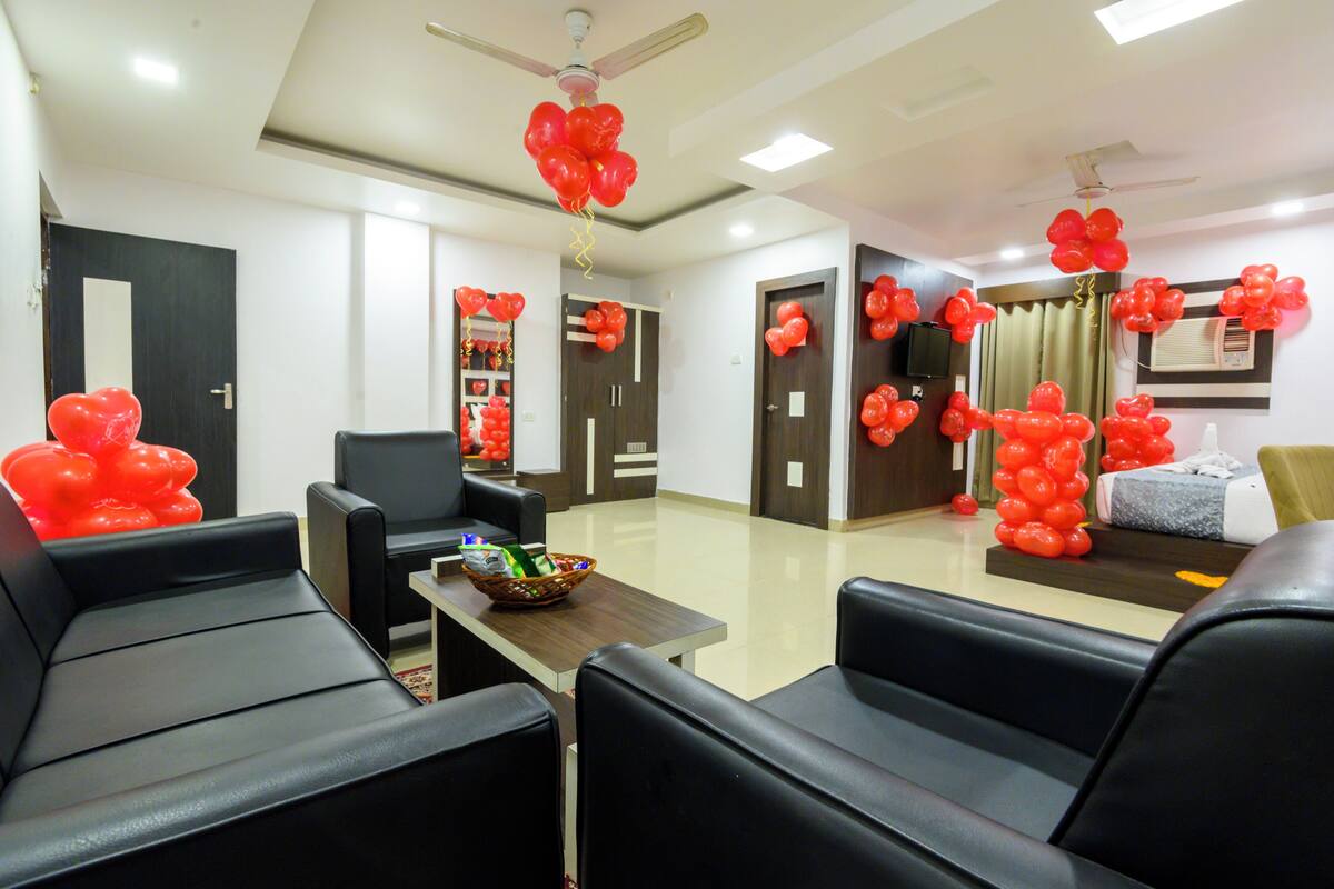 A reception area with black leather seating, a wooden reception desk, and red balloon decorations.