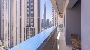 Een balkon met uitzicht op hoge gebouwen, waaronder een opvallend hoog kantoorgebouw.