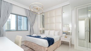 Een moderne hotelkamer met een groot bed, een nachtkastje met een lamp, een kast en uitzicht op de stad door het raam.