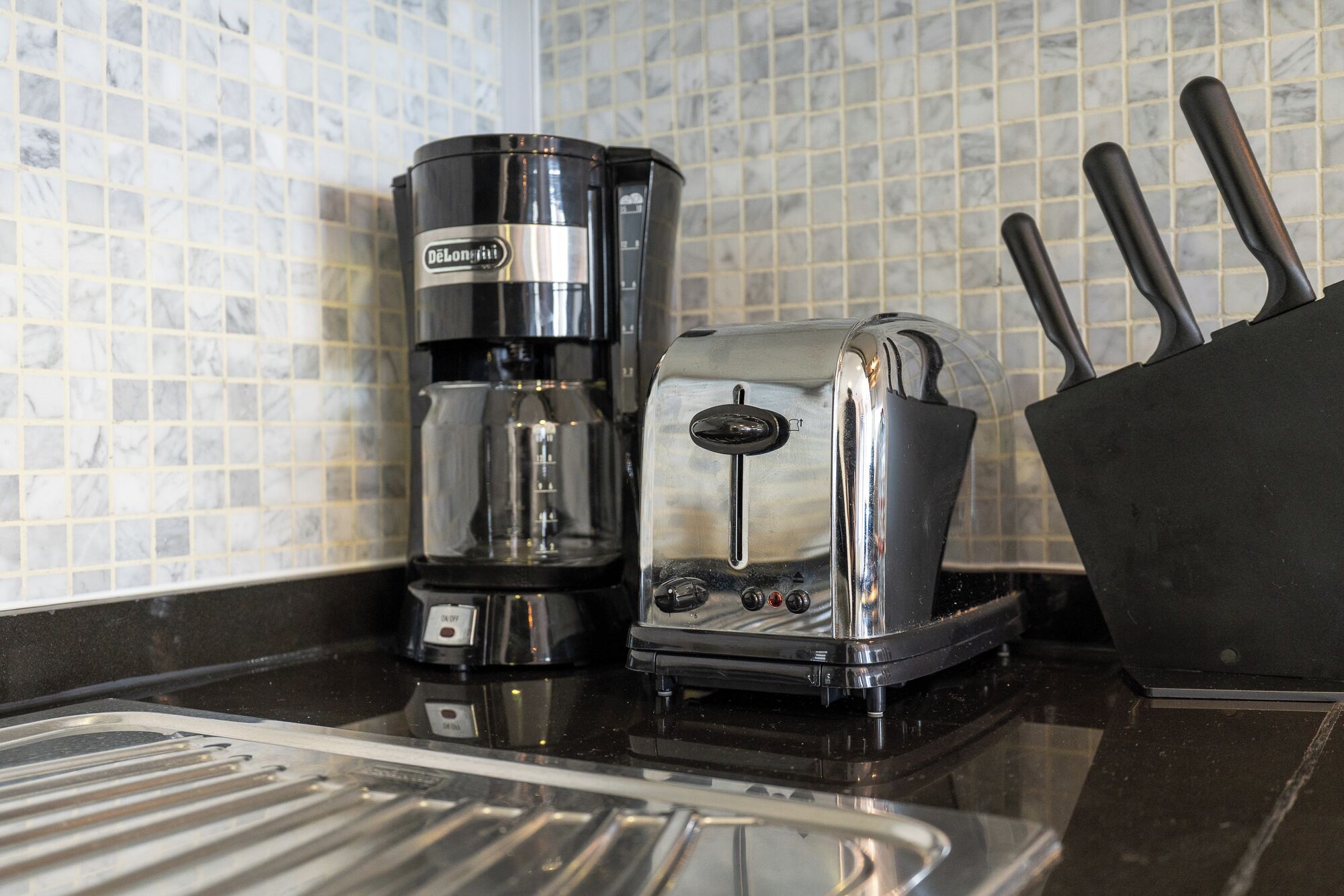 Una cocina con una cafetera y un tostador sobre la encimera.