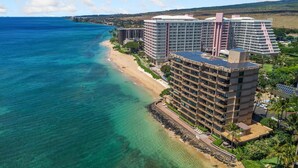 A high-rise hotel with multiple balconies overlooking a beach and ocean.
