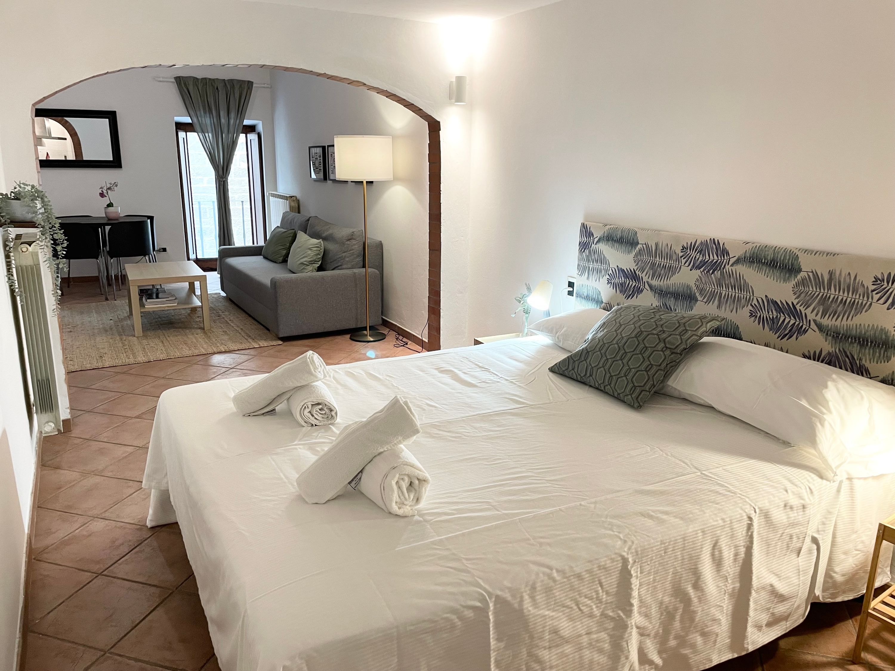 Habitación de hotel con una cama grande, un sofá, una mesita y un escritorio.