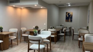 A modern dining area with wooden tables and chairs, recessed lighting, and a painting on the wall. - Solis Boutique Hotel (Istanbul)
