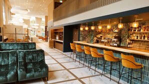 A modern bar area with a marble-tiled floor, a bar counter, and several yellow bar stools.