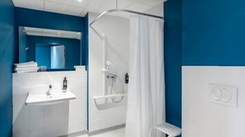 A modern bathroom with a shower, sink, and mirror.