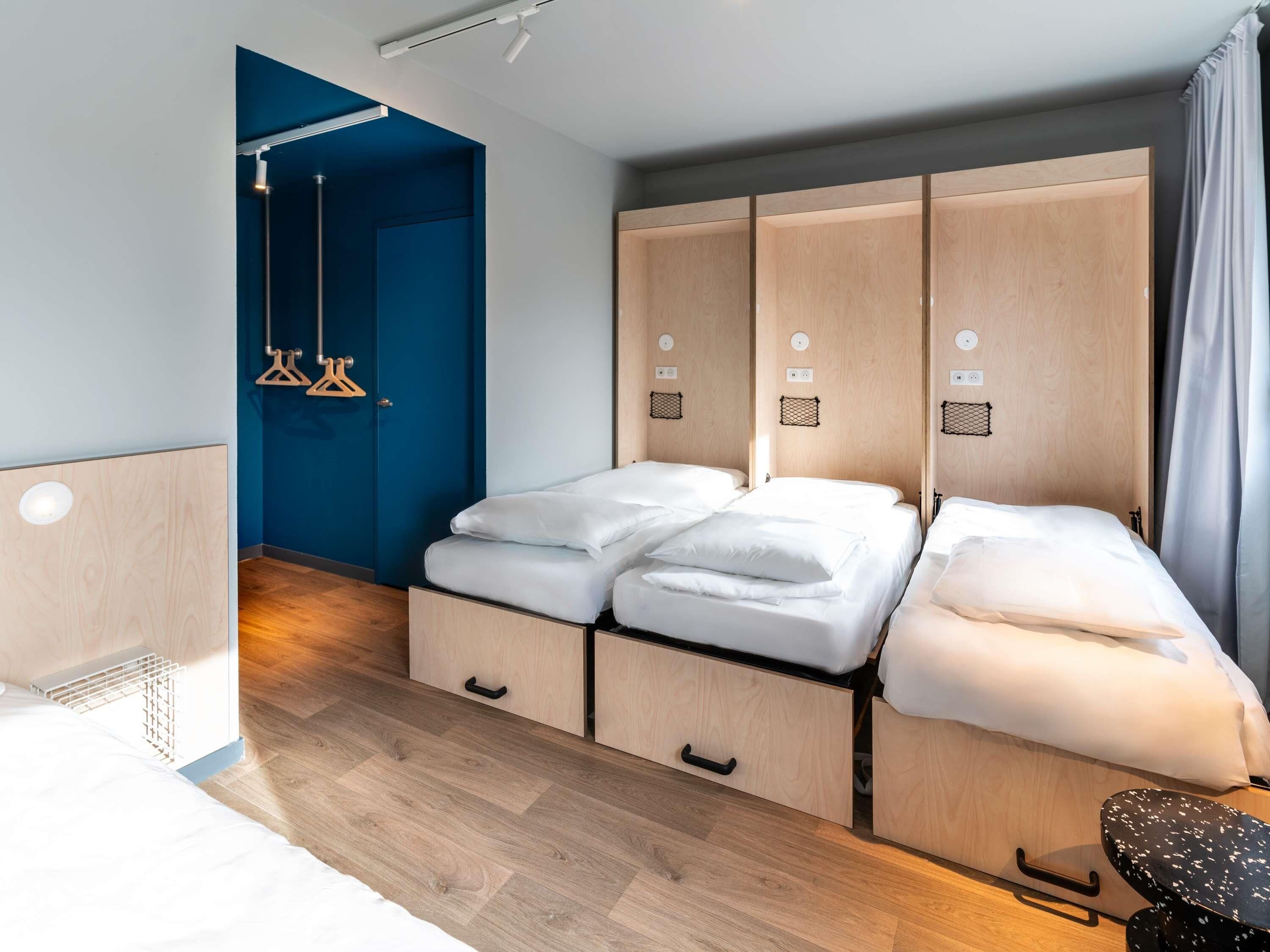 Une chambre d’hôtel avec un lit, un bureau et une armoire.
