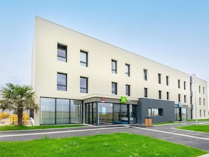 A modern building with a flat facade, large windows, and a glass entrance. - Ibis Budget Morlaix (Morlaix)