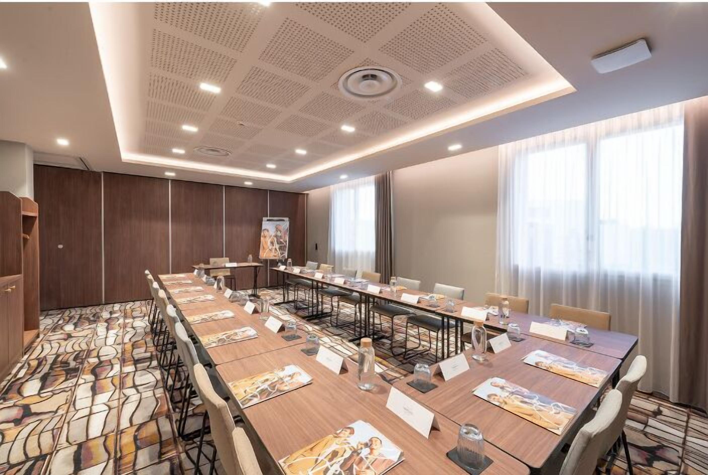 A conference room with a long table, nameplates, and chairs.
