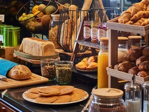 A breakfast buffet with various breads, pastries, and condiments. - Mercure Paris Butte Montmartre Basilique (Paris)