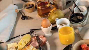 Ein Frühstücksbrett mit Eiern, Toast, Käse, Schinken, Obst und Getränken.
