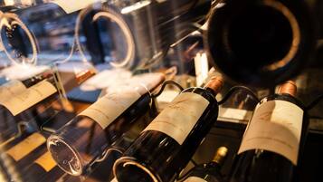 Una selezione di bottiglie di vino con etichette, disposte in una teca espositiva.