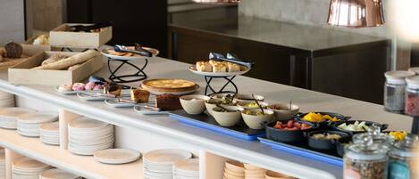 A buffet setup with various food items and utensils.