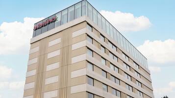 Un moderno edificio de hotel con fachada de vidrio y un letrero llamativo en la parte superior.