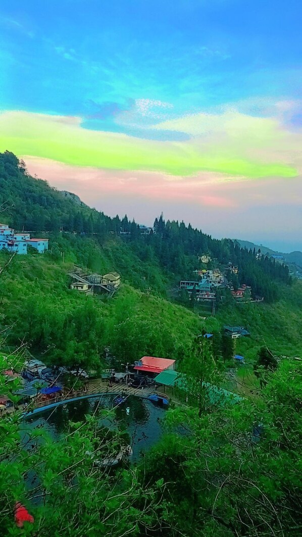 A mountainous landscape with scattered buildings, a bridge, and a body of water.