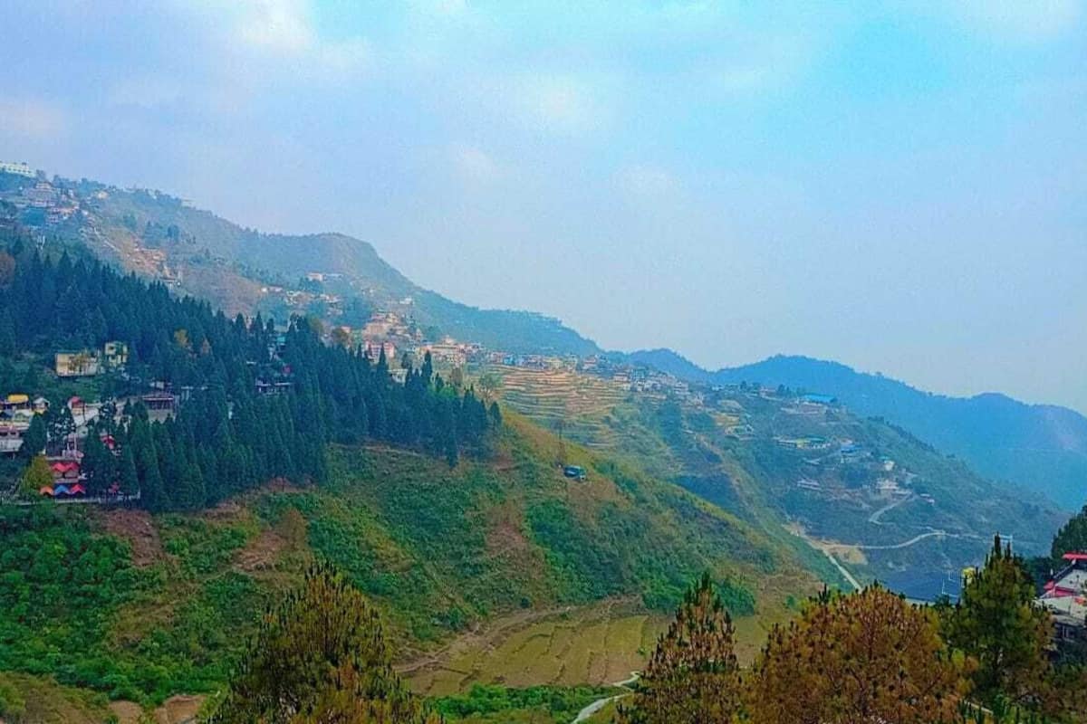 A mountainous landscape with terraced fields and scattered buildings.