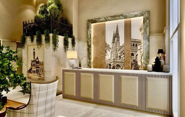 A reception area with a large framed picture of a cathedral, a reception desk, and a chair. - HOTEL MUMBAI HOUSE MINDSPACE MALAD (Mumbai)