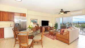 A modern living room with a dining area, a large flat-screen TV, and a balcony with a view. - Gorgeous Ocean View Suite at Waikiki Shore! Steps to Beach! Heart of Waikiki! (Honolulu)