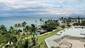 A resort with a pool, palm trees, and a view of the ocean. - Gorgeous Ocean View Suite at Waikiki Shore! Steps to Beach! Heart of Waikiki! (Honolulu)