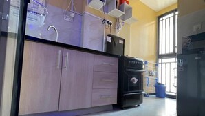 Une cuisine équipée d’un four encastré, d’un réfrigérateur et d’un évier. Elle comprend également des placards et un plan de travail.