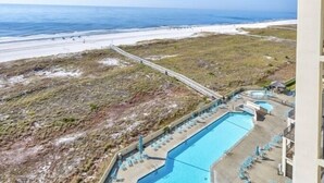 Un complexe hôtelier doté d’une grande piscine, d’un accès à la plage et d’un pont piétonnier.