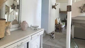 Um quarto com cômoda branca, um espelho e um cão deitado no chão.