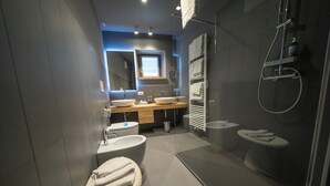 A modern bathroom with a double sink, a toilet, a bidet, and a glass-enclosed shower area. - Refined and elegant hotel in the center of Sappada (Sappada)