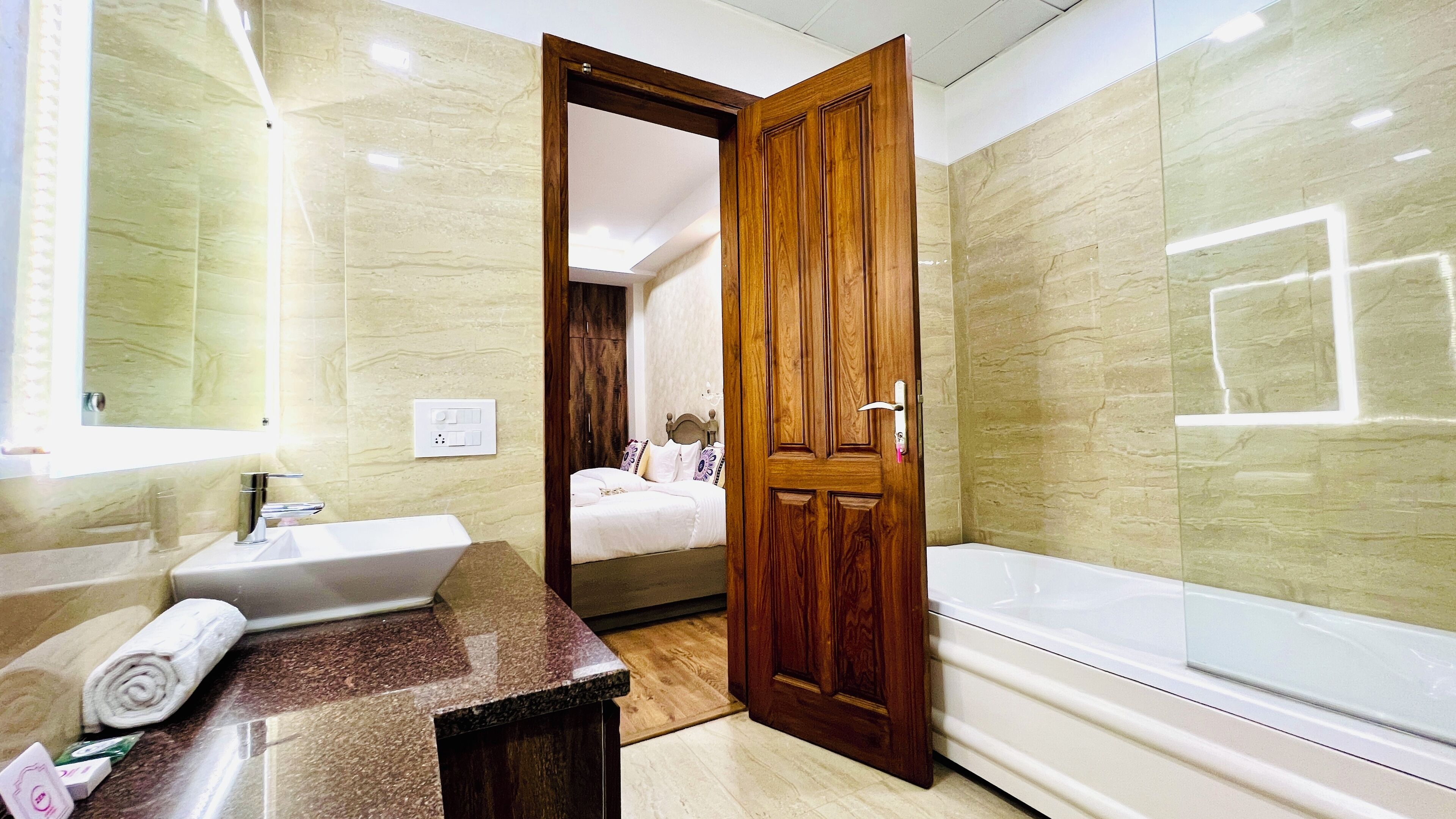 A bathroom with a sink, mirror, and bathtub.