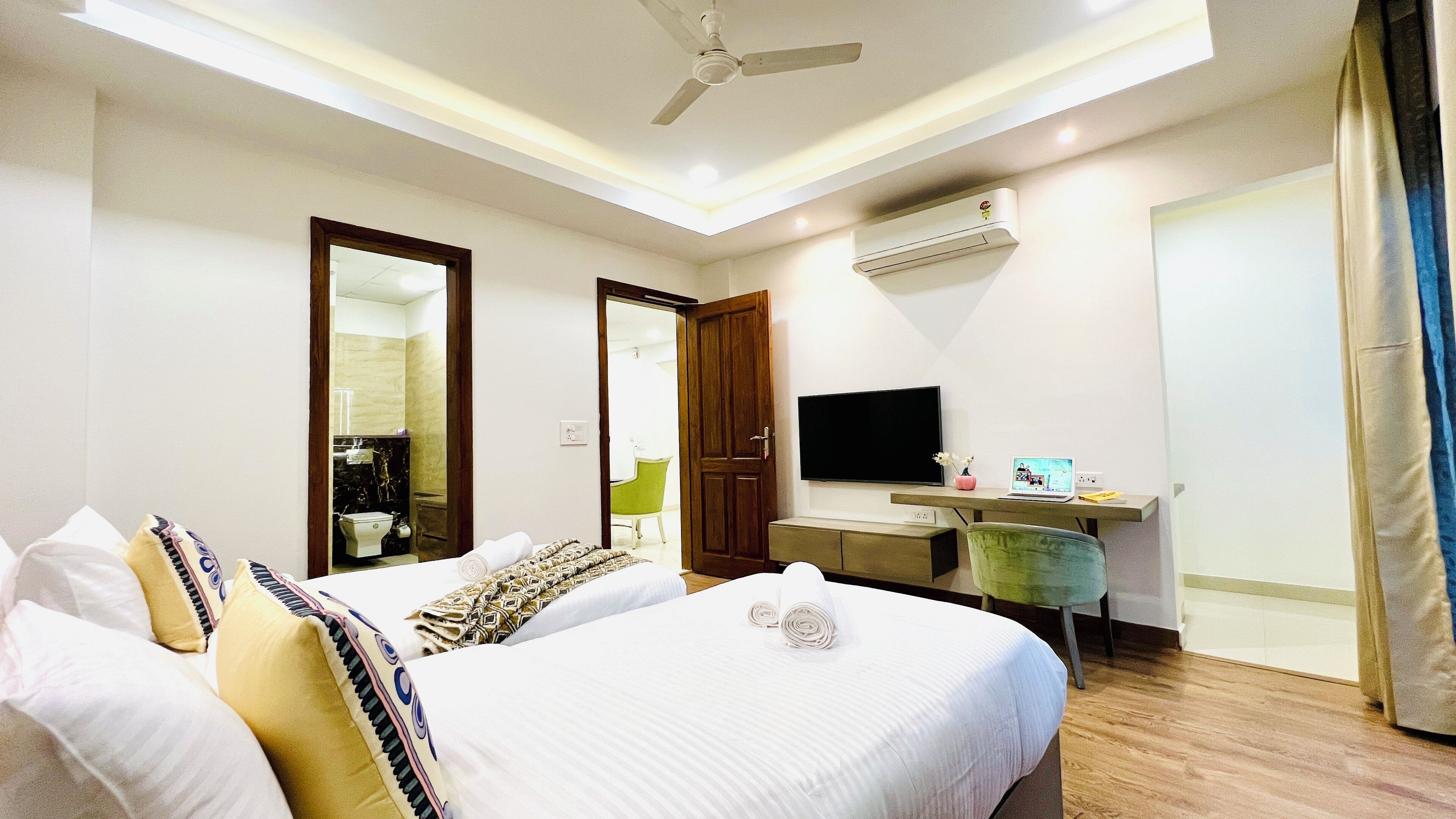 Une chambre d’hôtel équipée d’un lit, d’un bureau avec un ordinateur portable, d’une télévision et d’un appareil de climatisation.