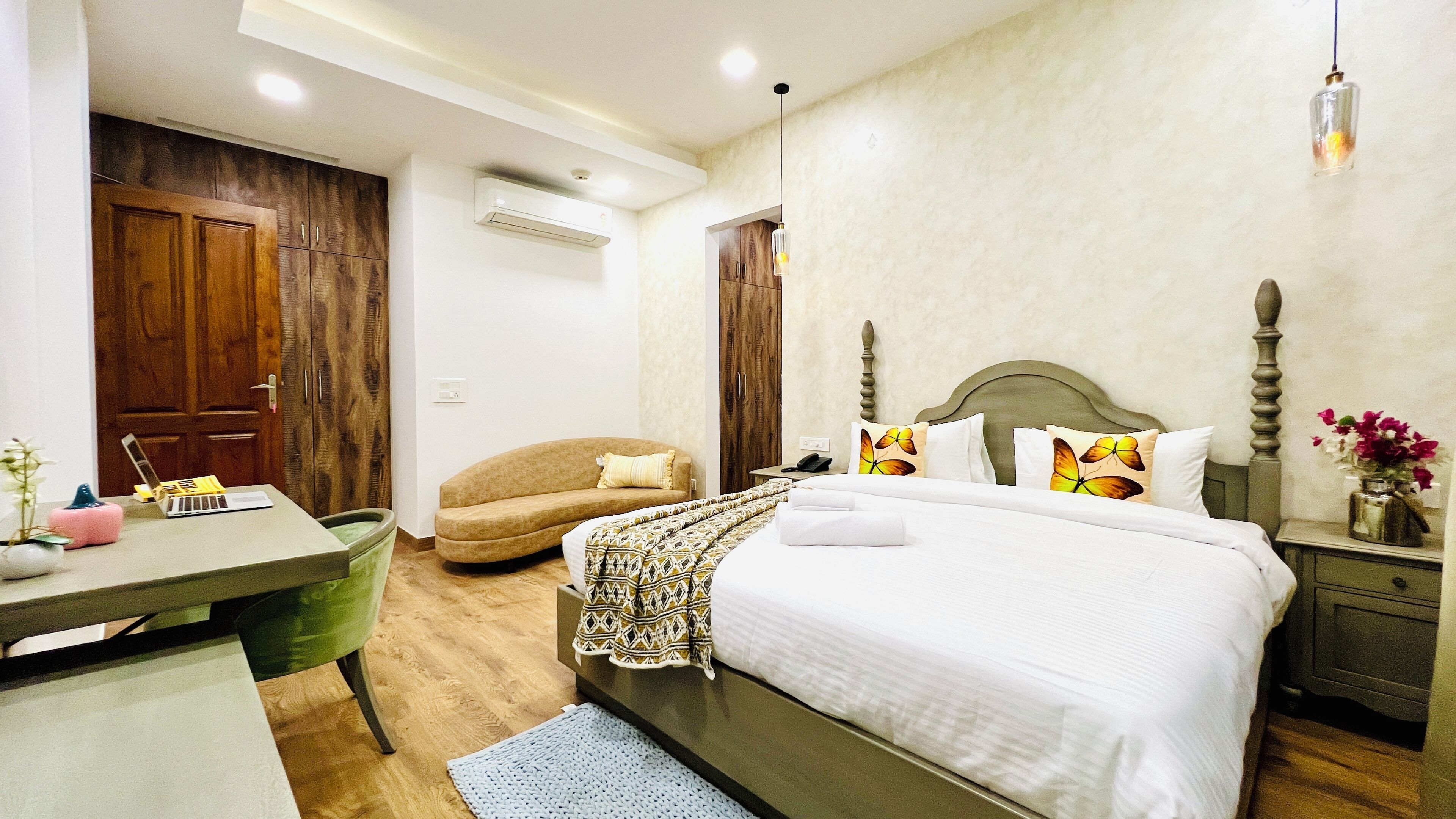A bedroom with a bed, bedside table, chair, desk, and wardrobe.