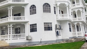 A large, multi-story building with balconies and arched windows. - Comfy Haven (Montego Bay)