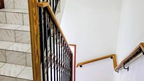 A staircase with marble steps and wooden handrails. - Comfy Haven (Montego Bay)
