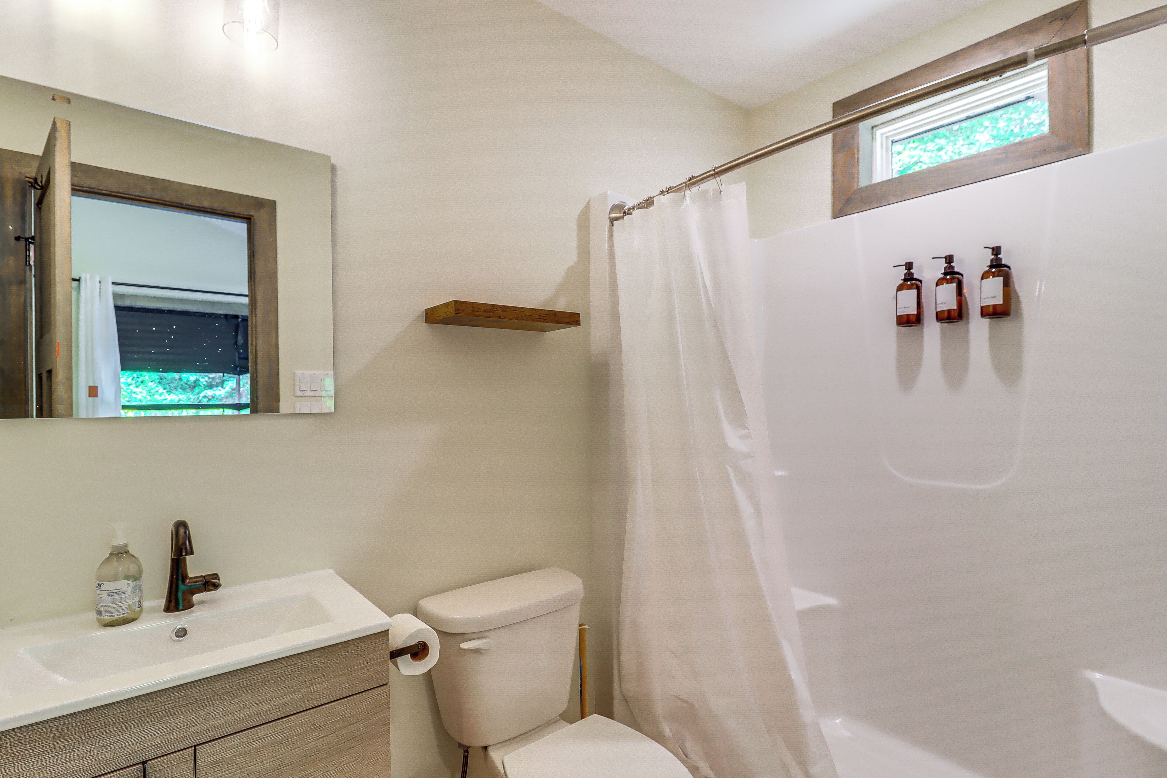 A bathroom with a toilet, sink, and shower curtain.