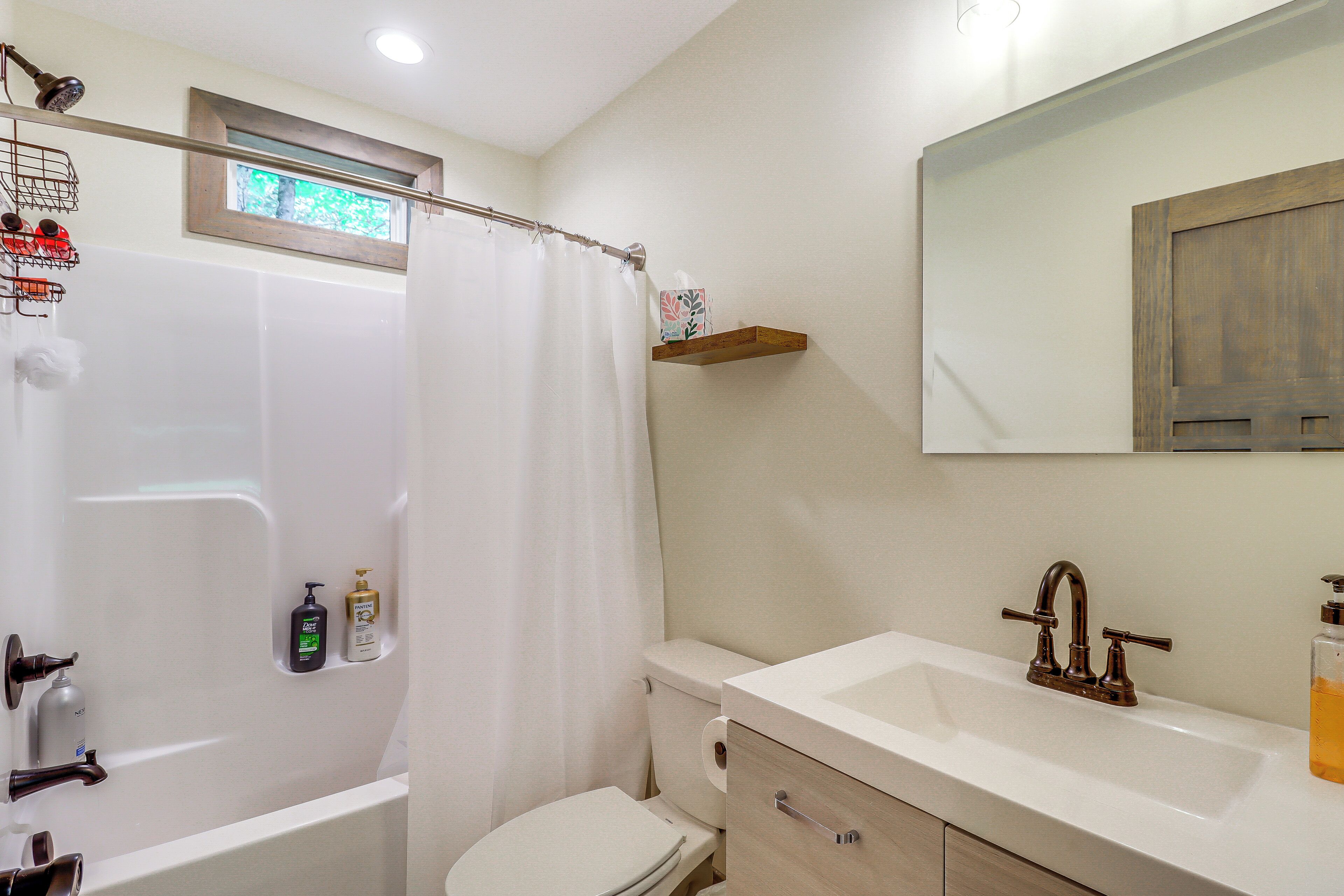 A bathroom with a bathtub, toilet, and sink.