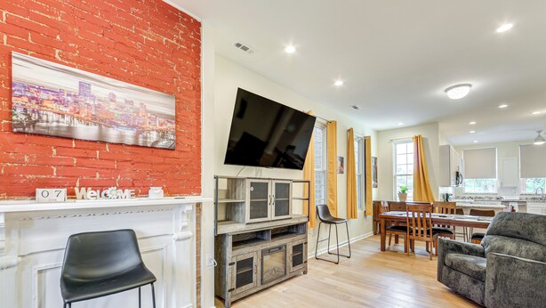 Una sala de estar moderna con chimenea, un televisor de pantalla plana y un comedor con muebles de madera.