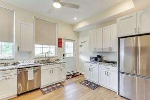 A modern kitchen with white cabinetry, stainless steel appliances, and a marble countertop. - Pittsburgh Home w/ Skyline Views: Walk to Stadium! (Pittsburgh)