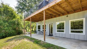 Eine überdachte Terrasse im Freien mit Holzdeck, großen Fenstern und einem Essbereich.