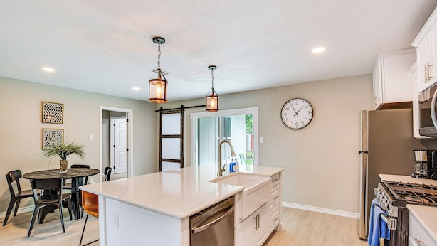 A modern kitchen with a central island, stainless steel appliances, and pendant lighting. - Walk to Lewisville Lake: Dog-friendly Texas Home (Little Elm)