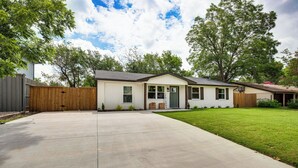 A single-story house with a front yard and a wooden fence. - Walk to Lewisville Lake: Dog-friendly Texas Home (Little Elm)