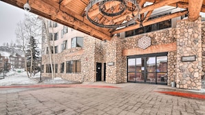Un edificio in pietra con una tettoia d'ingresso in legno e un'ampia finestra circolare.