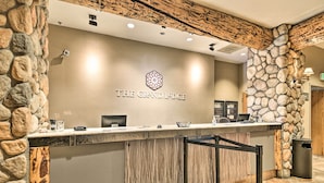 Una reception con parete in pietra e soffitto in legno, con la scritta "THE GRAND LODGE".