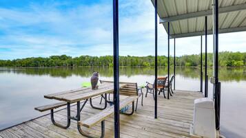 Enjoy a peaceful lakeside retreat with a deck featuring picnic tables and chairs.