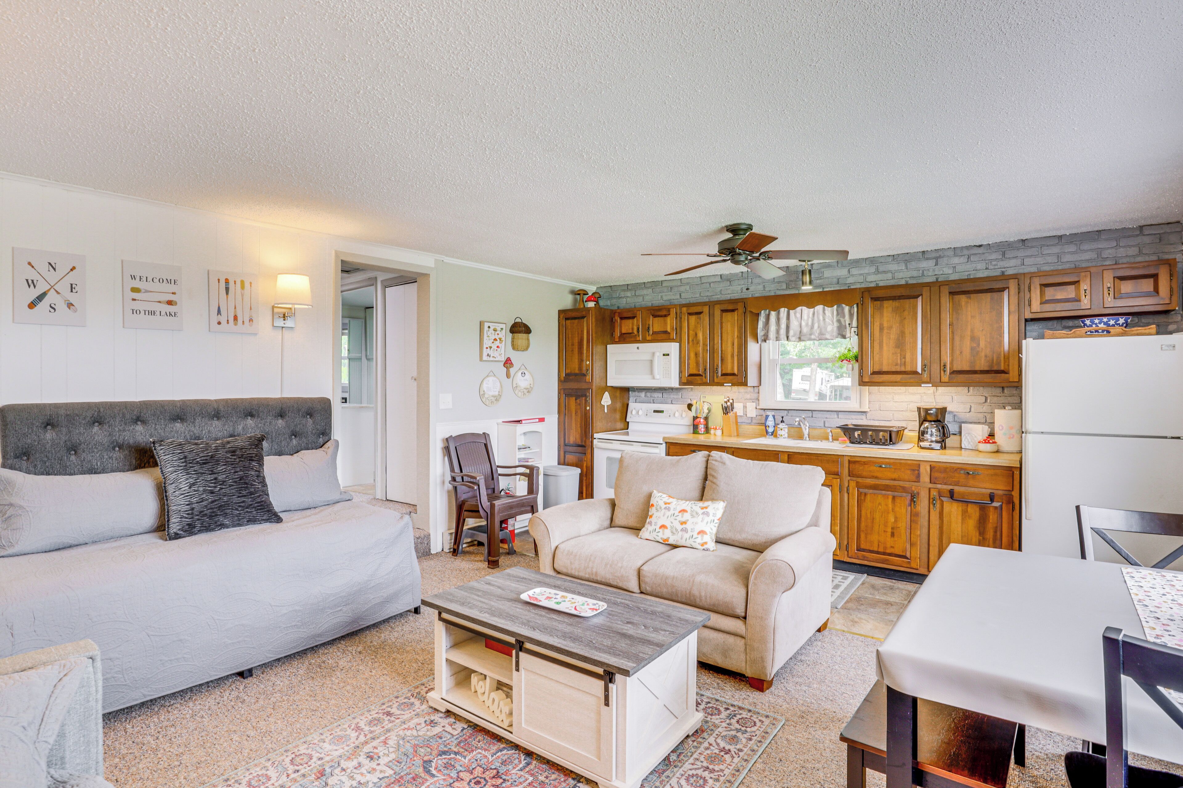 A cozy living room with a sofa, a coffee table, and a dining area with a table and chairs.