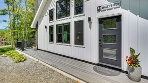 A white building with a sign reading "WALLY'S RUN" and a door with a window. - Near Hiking Trails & Ski Resorts: Killington Home! (Killington)