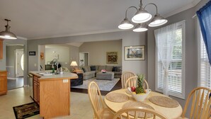 A spacious kitchen with wooden cabinets, a central island, and a dining area with wooden chairs and a table. - Unicoi Wine Trail Retreat! Bbq-ready Deck w/ Views (Sautee Nacoochee)