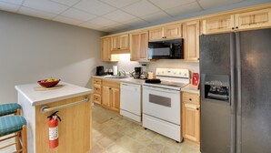 A kitchen with wooden cabinets, a white countertop, a stainless steel refrigerator, a microwave, a dishwasher, and a gas stove. - Wine Trail Apt 7 Mi to Yonah Mtn! Patio & Views (Sautee Nacoochee)