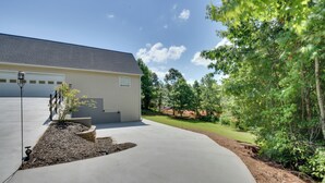 A residential house with a garage, a driveway, and a well-maintained lawn. - Wine Trail Apt 7 Mi to Yonah Mtn! Patio & Views (Sautee Nacoochee)